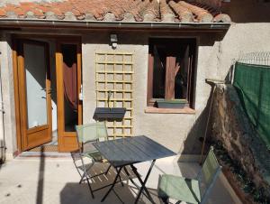 une table et des chaises assises à l'extérieur d'une maison dans l'établissement Au pied des Remparts 10 rue Saint jean, à Villefranche-de-Conflent