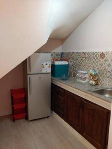 La cuisine est équipée d'un réfrigérateur blanc et d'un évier. dans l'établissement Appartement T2 avec terrasse et Vue mer à Béjaïa proche plage, à Béjaïa
