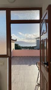 uma porta para uma varanda com vista para o oceano em Osmenaj Studios em Vlorë