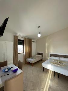 um quarto grande com duas camas e uma mesa em Osmenaj Studios em Vlorë