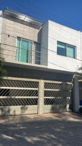 a house with a garage door and a building at Casa vacacional los olivos in San Blas