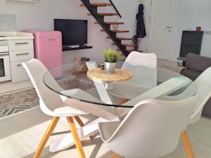 une salle à manger avec une table en verre et des chaises blanches dans l'établissement Esperanza 5, à Lebrija