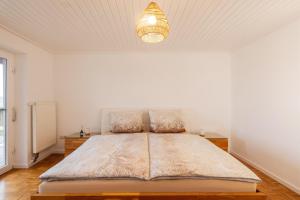 een slaapkamer met een groot bed in een witte kamer bij Alpenblick Familienparadies in der Bodenseeregion in Ravensburg