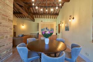 uma sala de jantar com uma mesa de madeira e cadeiras azuis em M&M Holiday House Umbrian Modern House with Swimming Pool em Antognola
