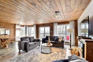 Sala de estar con 2 sofás y mesa en Chalet Jumeaux Mont Édouard Ski & Nature en LʼAnse-Saint-Jean