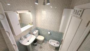 a bathroom with a sink and a toilet and a mirror at Alba Apartman Torrevieja in Torrevieja +17 photos