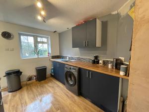 een keuken met een wasmachine en een wasmachine bij Barwell Manor - WFH Suite in Leicester