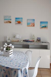 a dining room with a table and white chairs at Appartamento Lago Playa in Desenzano del Garda