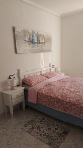a bedroom with a bed and a painting of sailboats at Alba Apartman Torrevieja in Torrevieja