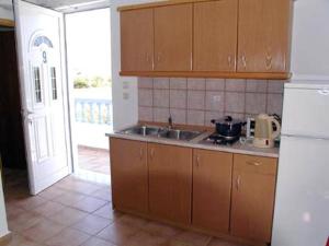 a kitchen with a sink and a door to a patio at LAKIS APPARTMENTS in Faliraki