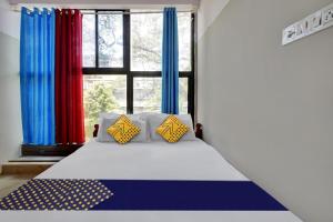 1 cama con 2 almohadas en una habitación con ventana en SPOT ON Canton Lodging And Boarding, en Bangalore