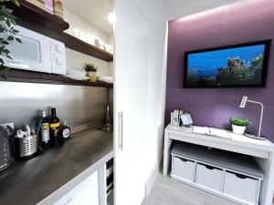 a kitchen with a tv on a purple wall at Apt 07 Beachside Beauty Central Studio Steps from Cafes in Brighton & Hove