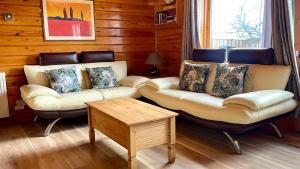 un soggiorno con 2 divani e un tavolo di Cowslip Lodge - Your Peaceful Retreat in South Devon a Chudleigh