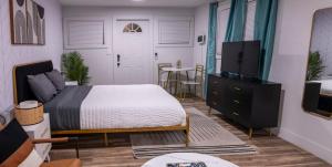 a bedroom with a bed and a tv and a table at New Downtown Tampa Cottage for 4 in Tampa
