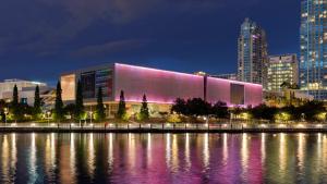 um edifício com uma fachada rosa ao lado de uma massa de água em New Downtown Tampa Cottage for 4 em Tampa