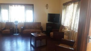 a living room with a couch and a tv at Lavania Villa in Attidiya