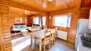 una sala da pranzo con tavolo in una cabina di legno di Cowslip Lodge - Your Peaceful Retreat in South Devon a Chudleigh