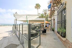 ein Restaurant am Strand mit dem Meer im Hintergrund in der Unterkunft Apartment Gaudi in Sitges