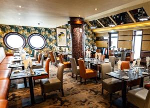 um restaurante com mesas e cadeiras num quarto em Ballymac Hotel em Stonyford