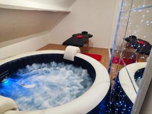 a bath tub filled with water in a room at Chambre spacieuse privée avec Jaccuzi in Talmas