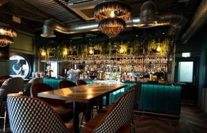 een restaurant met een houten tafel en een bar bij Luxury Lakeside Lodge, Hot Tub & Private Fishing in Tattershall