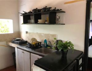 a kitchen sink with pots and pans on a shelf at Apartamentos Sol de Coveñas TI in Coveñas