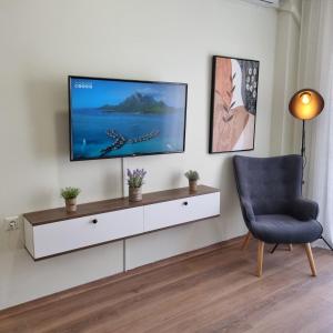 a living room with a flat screen tv on a wall at Fine Living Central in Heraklio
