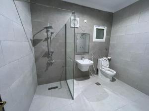 a bathroom with a shower and a toilet and a sink at Jabal Al Nour Apartment in Makkah