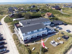 eine Luftansicht eines Gebäudes mit einem Parkplatz in der Unterkunft Klithjem Badehotel in Vejers Strand