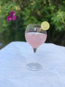 Un vaso de bebida rosada con limón. en Klithjem Badehotel en Vejers Strand