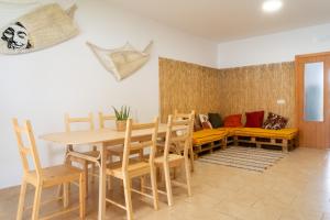 una sala da pranzo con tavolo, sedie e divano di Namawa Surfhouse a Chiclana de la Frontera