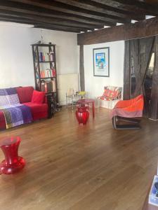 a living room with a red couch and a wooden floor at Appartement Saint-Paul Le Marais in Paris +6 photos