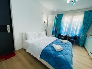 a bedroom with a blue and white bed and a table at maria house _2 in Kutaisi