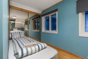 a bedroom with blue walls and a bed with mirrors at Villa Arctica in Tromsø