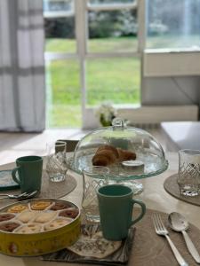 una mesa con un plato de repostería y un plato de vidrio en Eporedia 222 en Ivrea