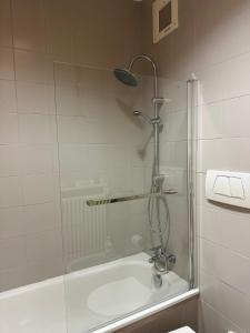 a bathroom with a shower and a tub with a shower head at Eporedia 222 in Ivrea