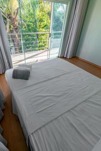 uma cama num quarto com uma grande janela em Suíte 1 - Pousada Karaiba em Uberlândia