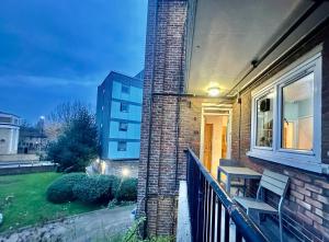 une maison en briques avec un banc sur une terrasse couverte dans l'établissement Victoria Park R4, à Londres