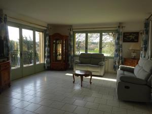 ein Wohnzimmer mit einem Sofa, einem Tisch und Fenstern in der Unterkunft gite la bonnelle piscine spa in Grillon