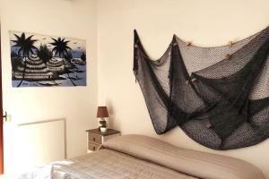 a bedroom with a net hanging on the wall at Confortevole Villino a San Felice Circeo in San Felice Circeo