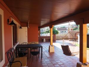 eine Veranda mit einem Tisch und Stühlen auf einer Terrasse in der Unterkunft Casa da Venda do Marco in Caldas da Rainha