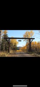 a picture of a gate in a field with trees at Heart West Haven in Priddis