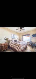 a bedroom with a bed and a ceiling fan at Heart West Haven in Priddis