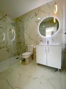 カジャオ・サルバヘにあるVilla Sueño Azulのバスルーム(洗面台、トイレ、鏡付)