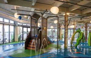 um parque infantil com escorrega numa sala com janelas em Luxury Lakeside Lodge, Hot Tub & Private Fishing em Tattershall