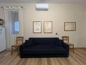 een woonkamer met een blauwe bank en 2 stoelen bij HIMERA LOFT - Holiday Home and Apartment in Termini Imerese