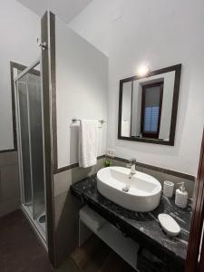 een witte badkamer met een wastafel en een douche bij HIMERA LOFT - Holiday Home and Apartment in Termini Imerese