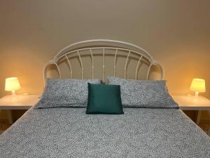 een bed met een groen kussen en 2 lampen bij HIMERA LOFT - Holiday Home and Apartment in Termini Imerese