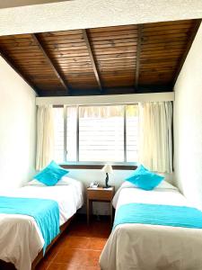 two beds in a room with a window at Hotel Concorde in Punta del Este