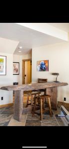 a large wooden table with benches in a room at Heart West Haven in Priddis